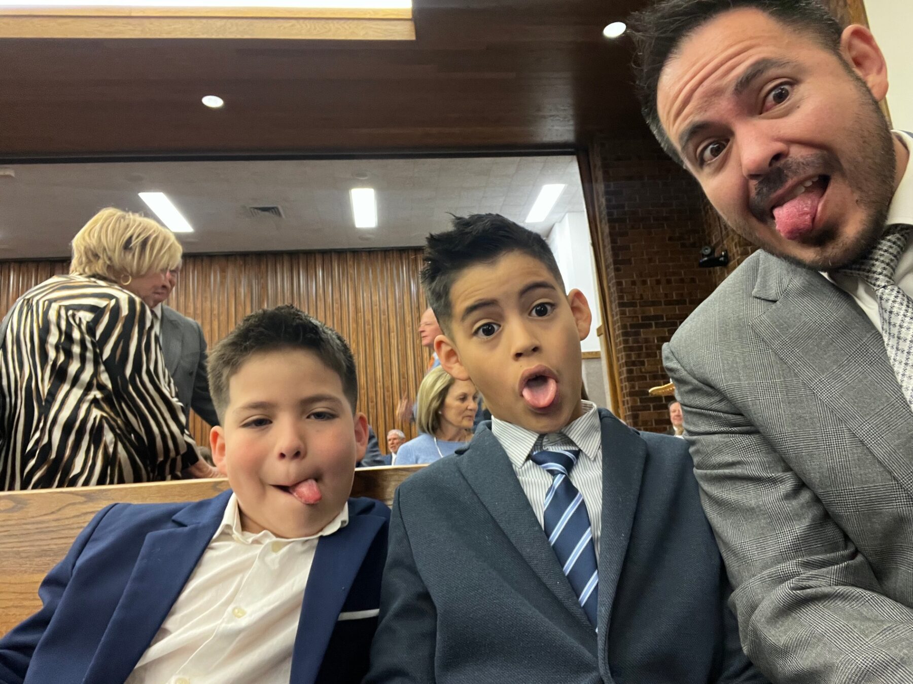 Oliver, his brother, and dad making silly faces at church.