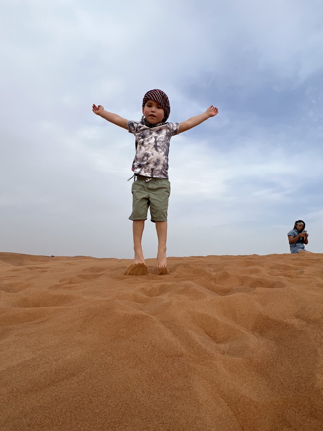 Oliver standing happily on top of a sand dune.