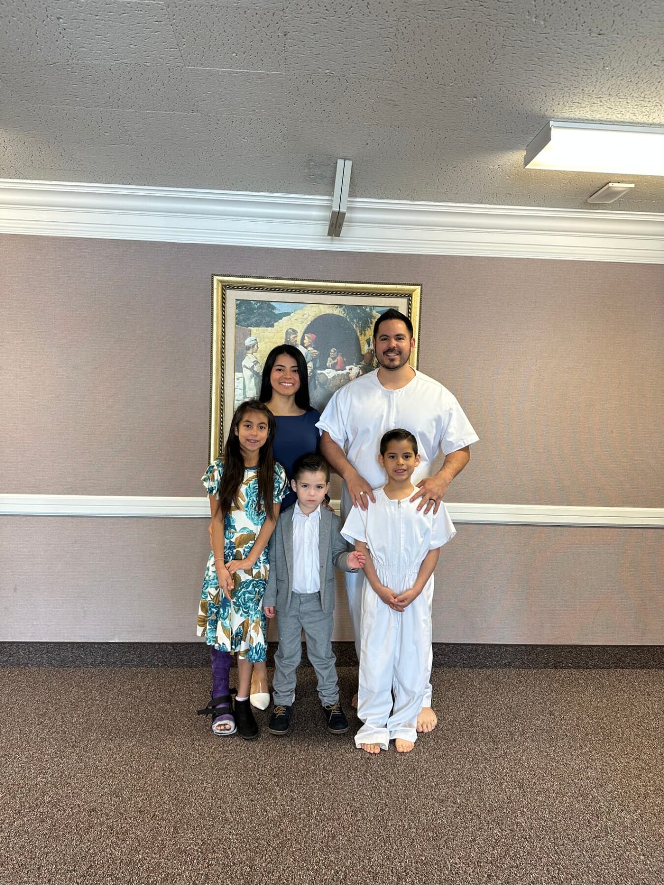 Oliver standing with his family at church.