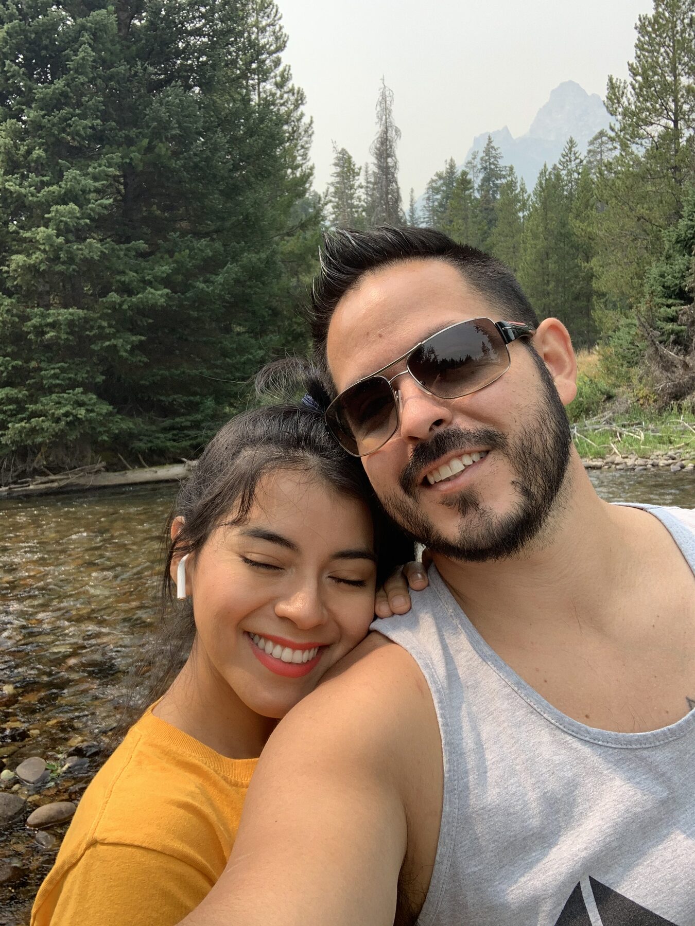 Oliver's mom and dad smiling together outdoors.